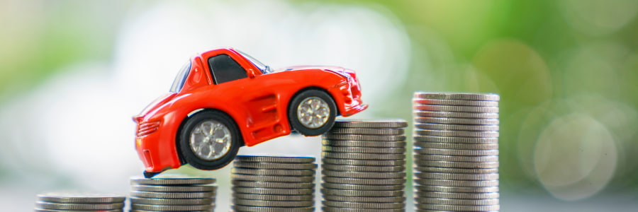 Toy car driving up money signifying ev fleet benefits.