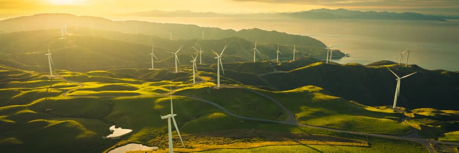 Wind turbines in a rural landscape at sunset.